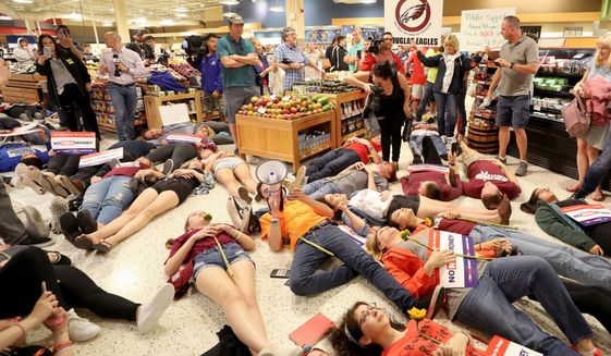 Demonstrators lie on the floor at a Publix Supermarket in Coral Springs, Florida, on Friday. Students from the Florida high school where 17 people were killed did a &quot;die in&quot; protest at the supermarket chain. (Associated Press)