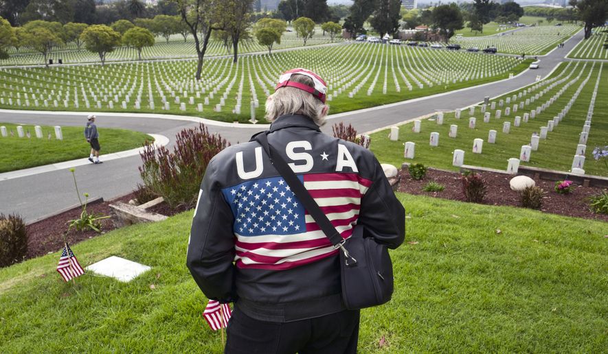 Mike Lackey pays his respects to fallen soldiers on Memorial Day at the Los Angeles National Cemetery in Los Angeles on Monday, May 28, 2018. (AP Photo/Richard Vogel)