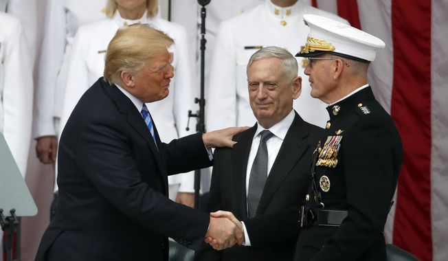 President Donald Trump shakes hands with Joint Chiefs Chairman Gen. Joseph Dunford, right, with Defense Secretary Jim Mattis in the center, at the Memorial Amphitheater in Arlington National Cemetery on Memorial Day, Monday, May 28, 2018 in Arlington, Va.(AP Photo/Alex Brandon)