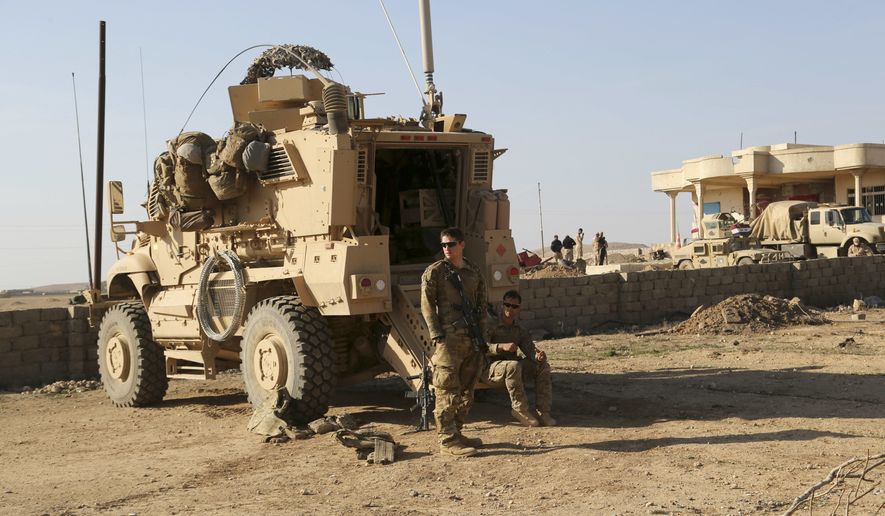 In this Thursday, Feb. 23, 2017, file photo, U.S. Army soldiers stand outside their armored vehicle on a joint base with Iraqi army south of Mosul, Iraq. (AP Photo/ Khalid Mohammed) ** FILE **