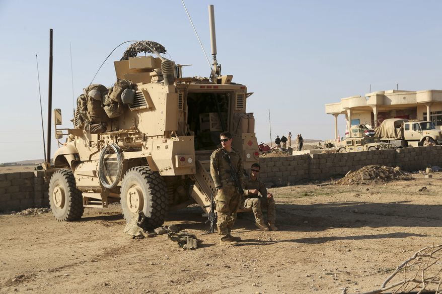 In this Thursday, Feb. 23, 2017, file photo, U.S. Army soldiers stand outside their armored vehicle on a joint base with Iraqi army south of Mosul, Iraq. (AP Photo/ Khalid Mohammed) ** FILE **