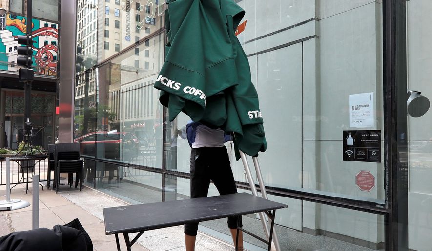 A Starbucks employee takes outside seating umbrellas inside a store in Chicago&#39;s famed Loop Tuesday, May 29, 2018, in Chicago. Starbucks is closing more than 8,000 U.S. stores for a few hours Tuesday to conduct anti-bias training in the company&#39;s latest effort to deal with the fallout over the arrest of two black men at one of its shops in Philadelphia. (AP Photo/Charles Rex Arbogast)