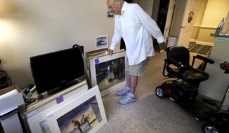 In this Thursday, May 24, 2018 photo, John Cook, a 99-year-old veteran, shows off his artwork in his room at the Kingston Care Center of Sylvania in Ohio. Cook is hosting an art show at his nursing home and his paintings will be sold by auction. (Samantha Madar/The Blade via AP)