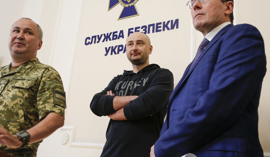 Russian journalist Arkady Babchenko, center, Vasily Gritsak, head of the Ukrainian Security Service, left, and Ukrainian Prosecutor General Yuriy Lutsenko attend a news conference at the Ukrainian Security Service on Wednesday, May 30, 2018. Babchenko turned up at a news conference in the Ukrainian capital Wednesday less than 24 hours after police reported he had been shot and killed at his Kiev apartment building. The country's security services said Babchenko's death was faked to foil a plot to take his life. (AP Photo/Efrem Lukatsky)
