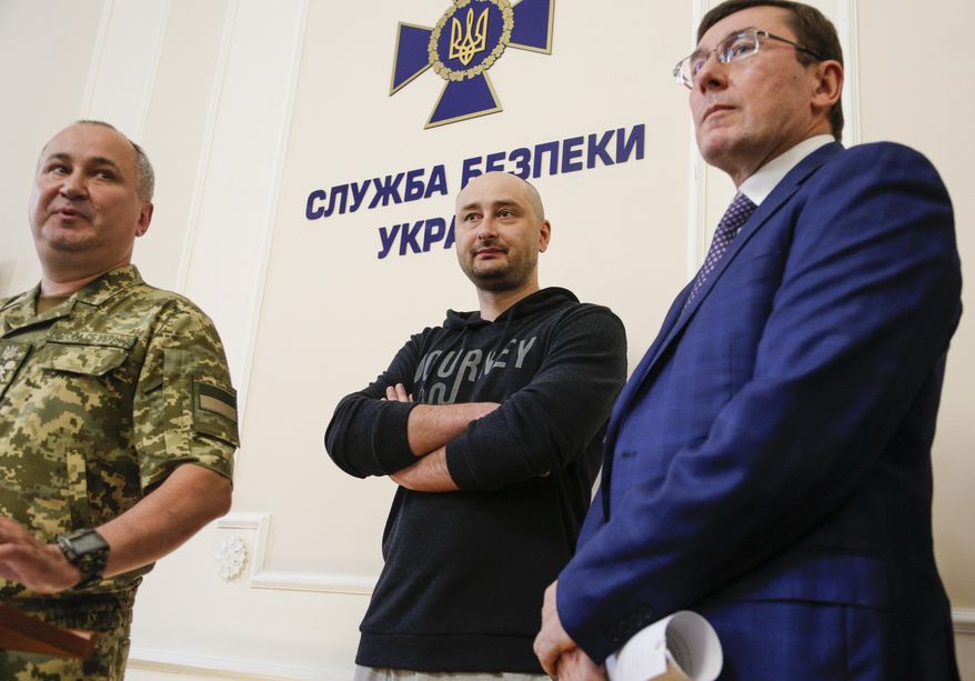 Russian journalist Arkady Babchenko, center, Vasily Gritsak, head of the Ukrainian Security Service, left, and Ukrainian Prosecutor General Yuriy Lutsenko attend a news conference at the Ukrainian Security Service on Wednesday, May 30, 2018. Babchenko turned up at a news conference in the Ukrainian capital Wednesday less than 24 hours after police reported he had been shot and killed at his Kiev apartment building. The country's security services said Babchenko's death was faked to foil a plot to take his life. (AP Photo/Efrem Lukatsky)