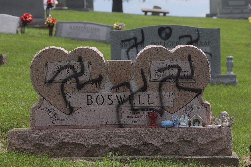 Grave markers with swastikas spray-painted on them stand in the Sunset Hill Cemetery in in Glen Carbon, Ill., on Saturday, May 26, 2018. Employees at the cemetery found swastikas on 150 to 200 headstones and police said swastikas were spray-painted on several homes nearby. (Laurie Skrivan/St. Louis Post-Dispatch via AP)