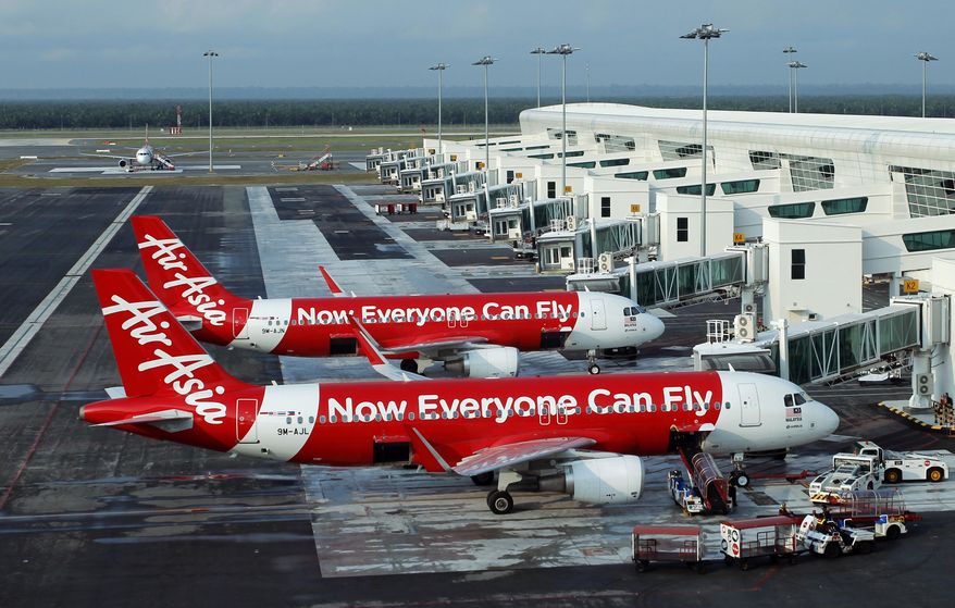 FILE - In this Nov. 10, 2014, file photo, AirAsia Airbus A320-200 passenger jets are parked on the tarmac in Sepang, Malaysia. AirAsia India Ltd., the Indian arm of regional budget airline AirAsia, has denied allegations it engaged in corruption, saying it was cooperating with an investigation into suspicions that it paid bribes to get government approvals. (AP Photo/Lai Seng Sin, File)