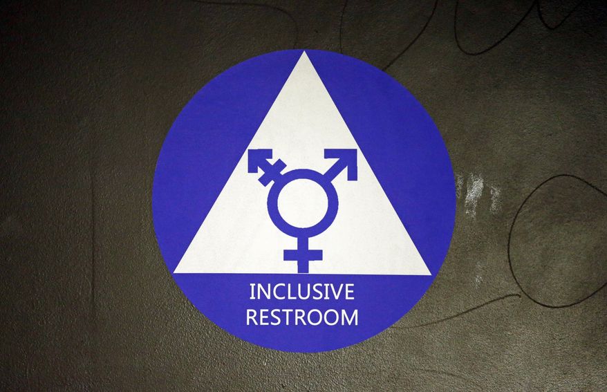 FILE - In this May 17, 2016, file photo, a new sticker designates a gender neutral bathroom at Nathan Hale high school in Seattle. On college campuses and in workplaces, across social media and in deference to nonbinary people, gender-neutral pronouns are more than just a new wave of political correctness. Pronouns “they” and “them” seem to be winning the race of acceptance as gender neutrals. (AP Photo/Elaine Thompson, File)