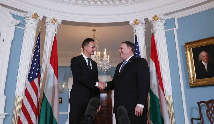 Secretary of State Mike Pompeo, right, shakes hands with Hungarian Minister of Foreign Affairs and Trade Peter Szijjarto, left, during their meeting at the US State Department in Washington, Wednesday, May 30, 2018. (AP Photo/Pablo Martinez Monsivais)