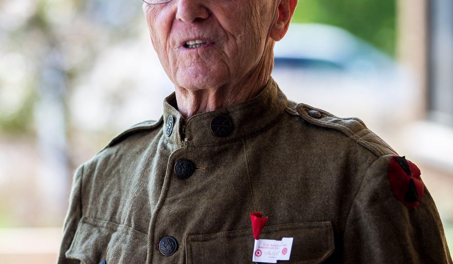 ADVANCE FOR USE SATURDAY, JUNE 2 - In this May 18, 2018 photo, Ervin Shudarek, 88, wears his father's World War I uniform as he hands out small, handmade poppies made of tissue paper for National Poppy Day at the Copps grocery store in Plover< Wis. (Alexandra Wimley/The Wausau Daily Herald via AP)