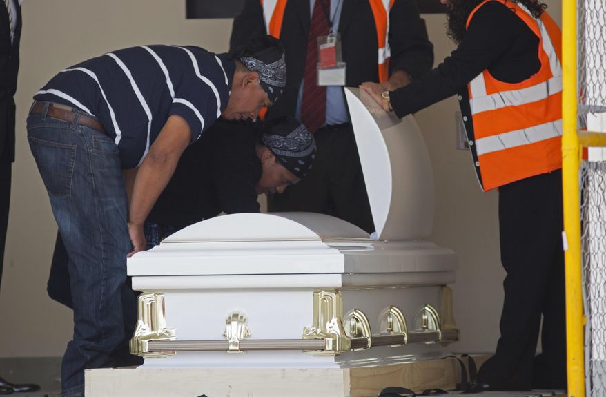 Lidia Gonzalez and Gilberto Gomez look at the body of their daughter Claudia Gomez Gonzalez, who was shot by a U.S. Border Patrol agent in Texas where she was trying to cross the border illegally, after her body was repatriated to Guatemala, at La Aurora international airport in Guatemala City, Thursday, May 31, 2018. The 19-year-old had graduated as a forensic accountant but was unable to attend college or find a job, so she had left Guatemala for the U.S., according to her aunt Dominga Vicente. (AP Photo/Moises Castillo)