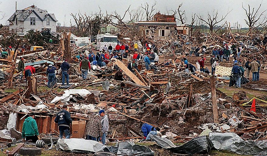 FILE - In this June 4, 1998, file photo, volunteers comb through rubble in Spencer S.D., after a tornado that tore through the town on May 30. The small southeastern community in South Dakota continues to recover two decades after the most destructive tornado in the state's history ripped through the city. (Val Hoeppner /The Argus Leader via AP, File)