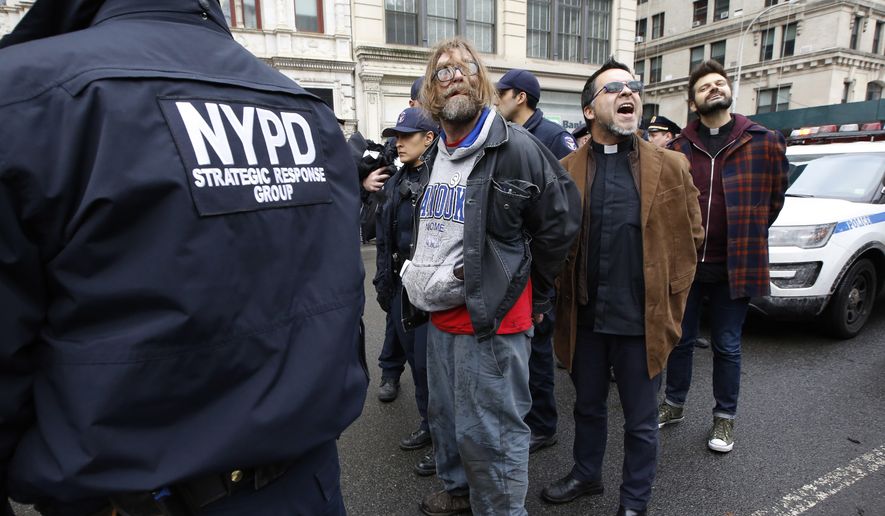 Protesters arrested demonstrating against the detention of prominent immigration activist Ravi Ragbir shout slogans as police prepare to lead them to squad cars, Thursday, Jan. 11, 2018, in New York. According to his attorney, Ragbir, a citizen of Trinidad, was handcuffed and detained by the federal government during a scheduled immigration check-in in lower Manhattan Thursday. Ragbir has been fighting deportation for years. (AP Photo/Kathy Willens)