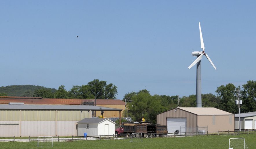 In this Thursday, May 17, 2018 photo, a wind turbine sits still near Industrial Park Road in Prairie Grove, Ark. TThe 100-foot wind turbine near the western edge of town stands as a guidepost, elaborate bird perch and lonely symbol of a renewable energy industry that just can't seem to take root in Arkansas. It's one of the only turbines in the state, more than 100 miles from the closest wind farm in Oklahoma, according to the U.S. Wind Turbine Database. (David Gottschalk/The Northwest Arkansas Democrat-Gazette via AP)