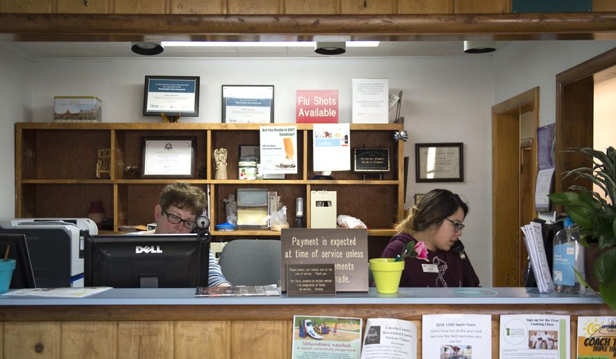 Front office employees take calls Monday, May 14, 2018, at Shoshone Family Medical Center in Shoshone, Idaho. A recent report by the Association of American Medical Colleges placed Idaho 49th in the nation for the number of physicians per capita.  (Drew Nash/The Times-News via AP)