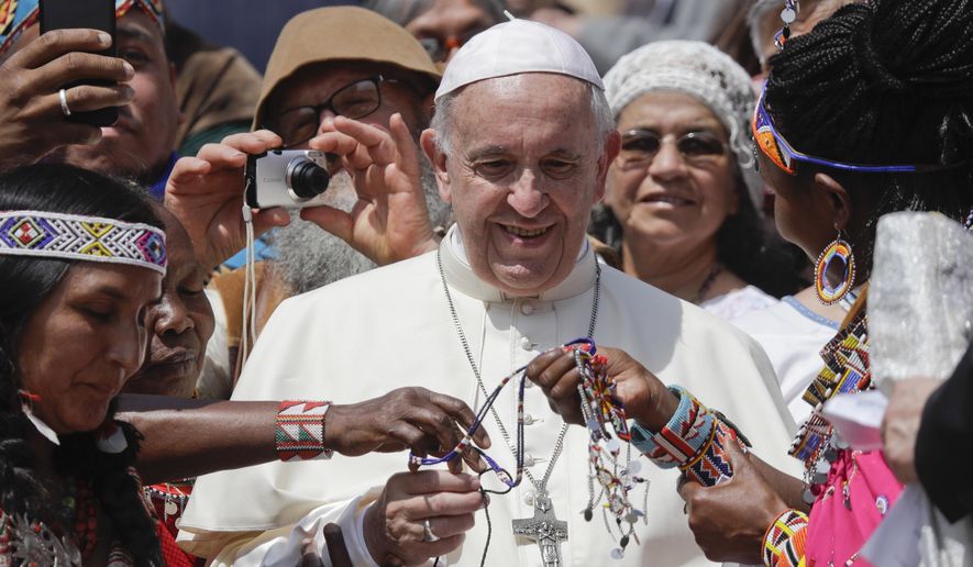 FILE - In this Wednesday, May 30, 2018 file photo, Pope Francis is given bracelets as he meets with some of the participants of the Spirit of The Planet Festival, an International gathering of Indigenous people, during weekly general audience in St. Peter's Square, at the Vatican. Pope Francis will meet with some of the world’s oil executives next week, likely to give them another moral nudge to clean up their act on global warming. (AP Photo/Gregorio Borgia, File)