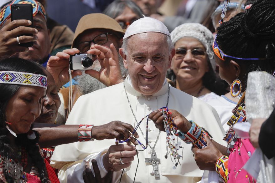 FILE - In this Wednesday, May 30, 2018 file photo, Pope Francis is given bracelets as he meets with some of the participants of the Spirit of The Planet Festival, an International gathering of Indigenous people, during weekly general audience in St. Peter's Square, at the Vatican. Pope Francis will meet with some of the world’s oil executives next week, likely to give them another moral nudge to clean up their act on global warming. (AP Photo/Gregorio Borgia, File)