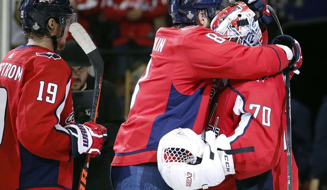 Washington Capitals forward Alex Ovechkin, center, of Russia, celebrates with goaltender Braden Holtby, right, after the team&#x27;s 3-1 victory over the Vegas Golden Knights in Game 3 of the NHL hockey Stanley Cup Final, Saturday, June 2, 2018, in Washington. At left is Capitals forward Nicklas Backstrom, of Sweden. (AP Photo/Alex Brandon)