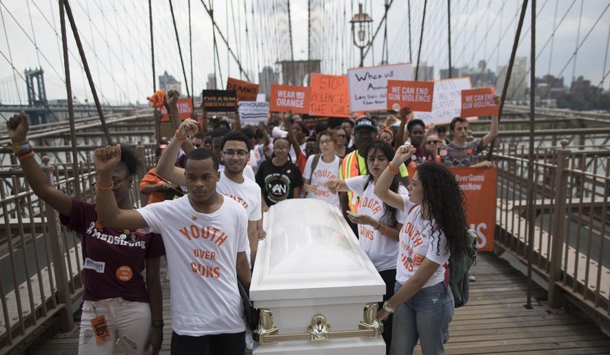 Demonstrators carry a coffin over the Brooklyn bridge during a march and rally against gun violence, Saturday, June 2, 2018, in New York. Youth Over Guns, a gun violence prevention organization in New York City, lead a march across the Brooklyn Bridge to call for youth empowerment and investment in urban communities to end gun violence. (AP Photo/Mary Altaffer)