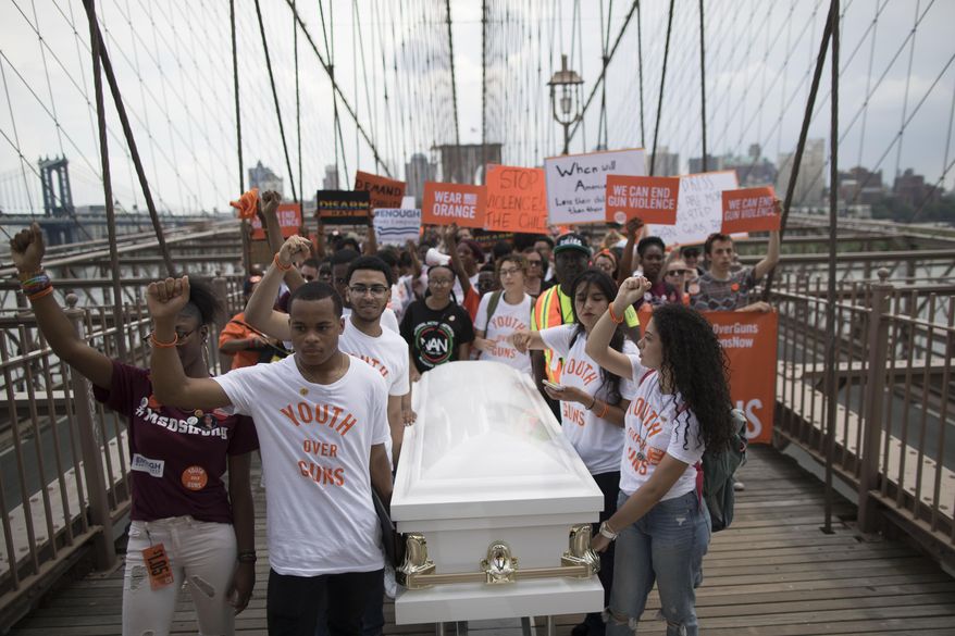 Demonstrators carry a coffin over the Brooklyn bridge during a march and rally against gun violence, Saturday, June 2, 2018, in New York. Youth Over Guns, a gun violence prevention organization in New York City, lead a march across the Brooklyn Bridge to call for youth empowerment and investment in urban communities to end gun violence. (AP Photo/Mary Altaffer)