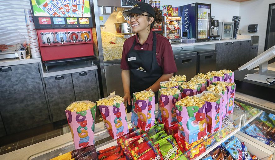 In this May 17, 2018 photo, McFarland High senior Victoria Sharp works at the food concession and is one of the high school students that acquired one of the coveted jobs at the Maya Cinemas Theater in Delano, Calif. For around a decade, the farm worker city of Delano, has lacked a movie theater. Residents from this largely Latino community had to travel nearly 40 miles to see the latest film a drive advocates say was rare since around a third of the population lives in poverty. This week, Moctesuma Esparza, a well-known Latino movie producer, opened his latest Maya Cinemas theater this month in the Central California city of 53,000 people as part of his ongoing effort to open movie theaters in poor, U.S. rural areas that lack basic entertainment options. (Henry A. Barrios/The Bakersfield Californian via AP)