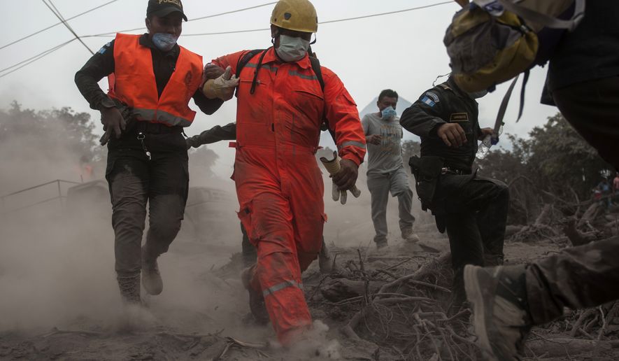 Firefighters and police are forced to evacuate a search and rescue effort as the Volcan de Fuego, or &quot;Volcano of Fire,&quot; continues to spill out smoke and ash in Escuintla, Guatemala, Monday, June 4, 2018. A fiery volcanic eruption in south-central Guatemala sent lava flowing into rural communities killing dozens. (AP Photo/Oliver de Ros)