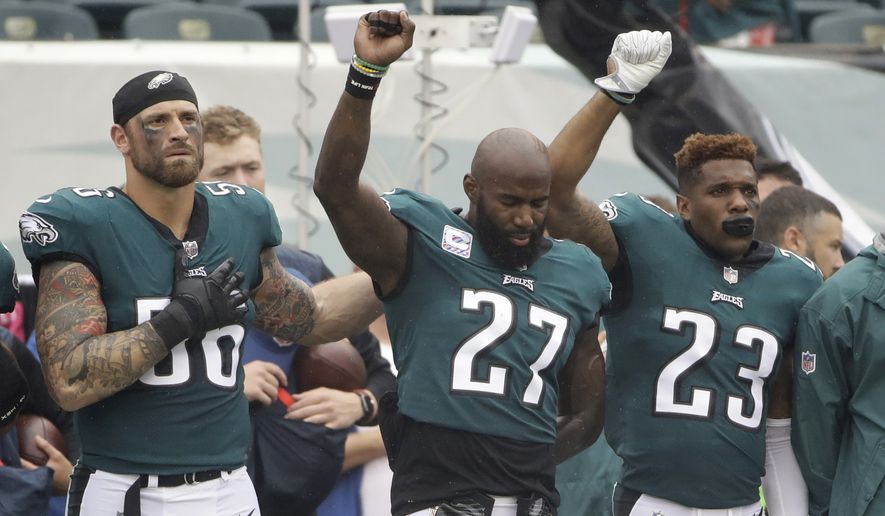 Philadelphia Eagles&#39; Chris Long (56), Malcolm Jenkins (27) and Rodney McLeod (23) gesture during the National Anthem before an NFL football game against the Arizona Cardinals, Sunday, Oct. 8, 2017, in Philadelphia. (AP Photo/Matt Rourke)