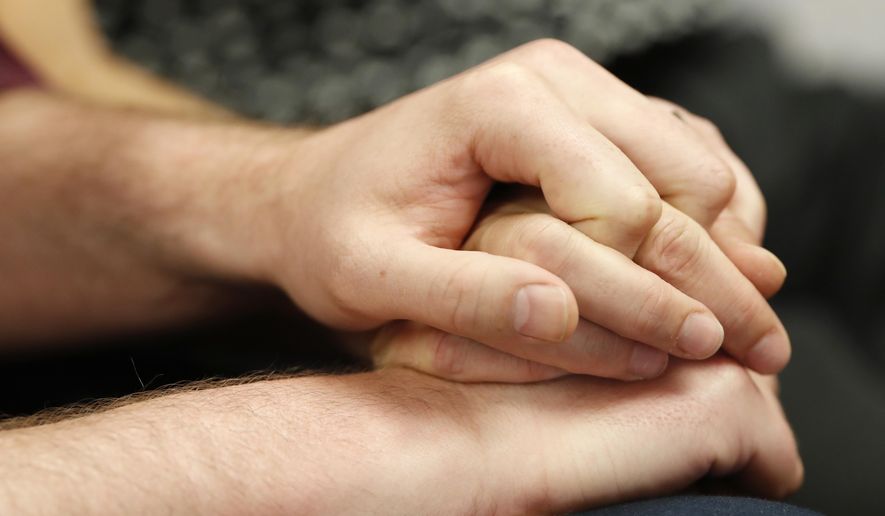 Charlie Craig and David Mullins hold hands as they talk about a U.S. Supreme Court ruling that sets aside a Colorado court decision against a baker who would not make a wedding cake for the same-sex couple as they meet reporters Monday, June 4, 2018, in Denver. The Court has not decided on the larger issue in the case, however--whether a business can refuse to to serve gay and lesbian people. (AP Photo/David Zalubowski)
