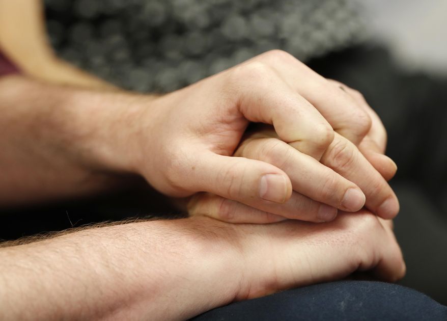 Charlie Craig and David Mullins hold hands as they talk about a U.S. Supreme Court ruling that sets aside a Colorado court decision against a baker who would not make a wedding cake for the same-sex couple as they meet reporters Monday, June 4, 2018, in Denver. The Court has not decided on the larger issue in the case, however--whether a business can refuse to to serve gay and lesbian people. (AP Photo/David Zalubowski)