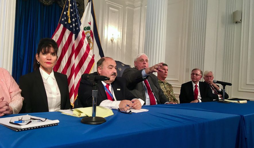 West Virginia Gov. Jim Justice, center, gestures as he answers questions at a news conference Monday, June 4, 2018, at the state Capitol in Charleston, W.Va. Justice was joined by other officials in announcing that a program to help flood victims find housing assistance will have new leadership. (AP Photo/John Raby)