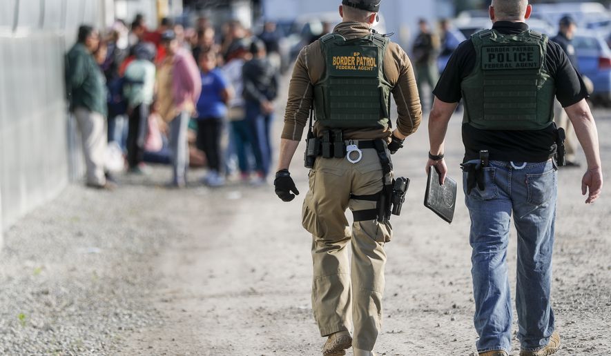 Government agents apprehend suspects during an immigration sting at Corso's Flower and Garden Center, Tuesday, June 5, 2018, in Castalia, Ohio. The operation is one of the largest against employers in recent years on allegations of violating immigration laws. (AP Photo/John Minchillo)