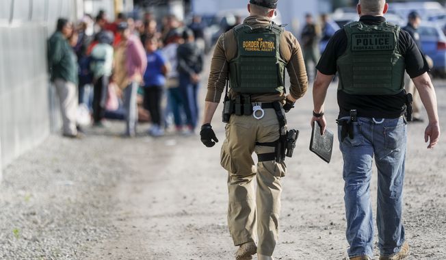 Government agents apprehend suspects during an immigration sting at Corso&#x27;s Flower and Garden Center, Tuesday, June 5, 2018, in Castalia, Ohio. The operation is one of the largest against employers in recent years on allegations of violating immigration laws. (AP Photo/John Minchillo)