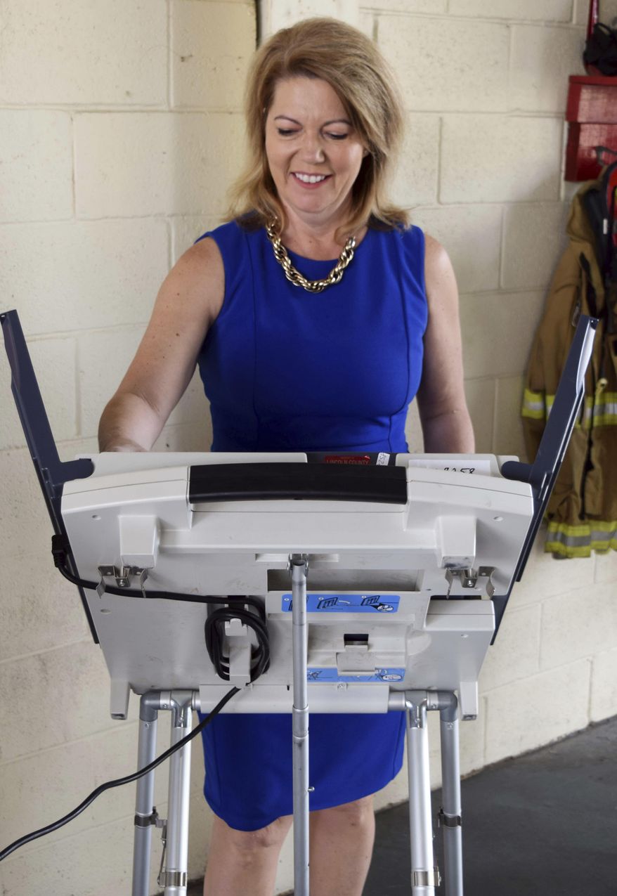 Republican State Sen. Sally Doty, a candidate for the Third Congressional District seat, left, votes in the party primary, at a Brookhaven, Miss., fire station, Tuesday, June 5, 2018. (Adam Northam/The Daily Leader via AP)