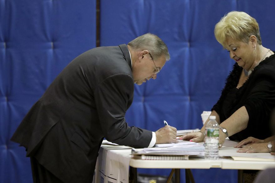 U.S. Sen. Bob Menendez checks in before casting his vote in the New Jersey primary election, Tuesday, June 5, 2018, at the Harrison Community Center in Harrison, N.J. (AP Photo/Julio Cortez)