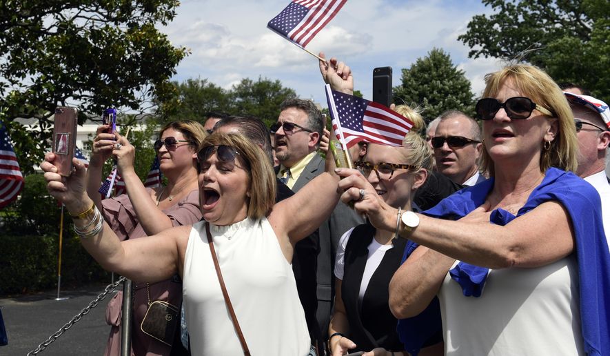 Guests wave flags and take photos as the national anthem is played during a &amp;quot;Celebration of America&amp;quot; event on the South Lawn of the White House in Washington, Tuesday, June 5, 2018. President Donald Trump quickly scheduled the event with military bands after canceling a visit with the Philadelphia Eagles as he stoked fresh controversy over players who protest racial injustice by taking a knee during the national anthem. (AP Photo/Susan Walsh)