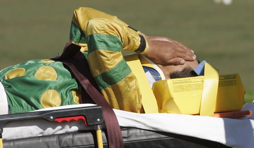 FILE - In this Sept. 1, 2007, file photo, jockey Edgar Prado is taken to an ambulance after falling from Admiral Bird at the conclusion of the seventh race at Saratoga Race Course in Saratoga Springs, N.Y. Doctors with experience treating concussions among jockeys consider it a major issue. In a sport where there is significant attention paid to the health and well-being of horses, jockeys and exercise riders are often an afterthought with inadequate medical care and insurance and limited disability protection. (AP Photo/Mike Groll, File)