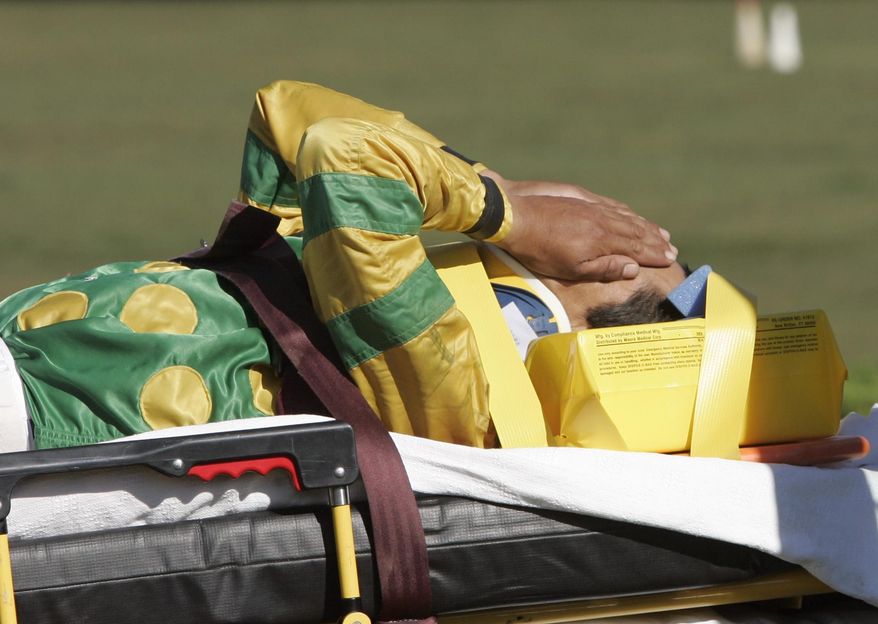 FILE - In this Sept. 1, 2007, file photo, jockey Edgar Prado is taken to an ambulance after falling from Admiral Bird at the conclusion of the seventh race at Saratoga Race Course in Saratoga Springs, N.Y. Doctors with experience treating concussions among jockeys consider it a major issue. In a sport where there is significant attention paid to the health and well-being of horses, jockeys and exercise riders are often an afterthought with inadequate medical care and insurance and limited disability protection. (AP Photo/Mike Groll, File)