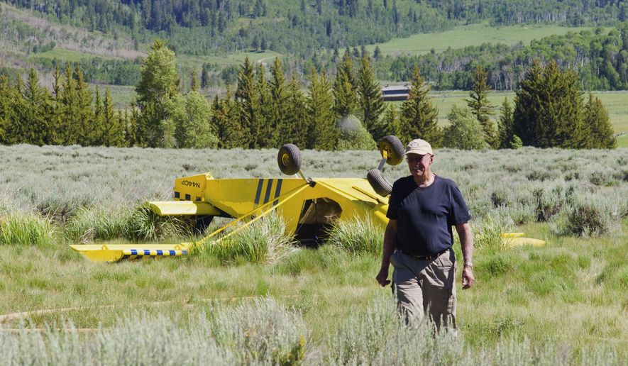 In this June 28, 2013, photo, Charles Peet walks away from his single-engine kit plane after crashing near his ranch in Hoback Canyon, Wyo. (Angus M. Thuermer Jr./Jackson Hole News & Guide via AP)