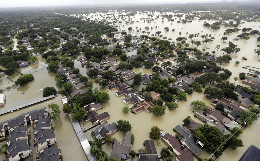 FILE - In this Aug. 29, 2017, file photo, water from Addicks Reservoir flows into neighborhoods as floodwaters from Tropical Storm Harvey rise in Houston. A new report on the damage caused by Hurricane Harvey says the U.S. has never experienced the amount of rainfall across such a vast area as that brought by Harvey when it struck Texas. The report released this week by the Harris County Flood Control District says more rain fell over a five-day period, and on such a broad area, than at any time since records have been kept. (AP Photo/David J. Phillip, File)
