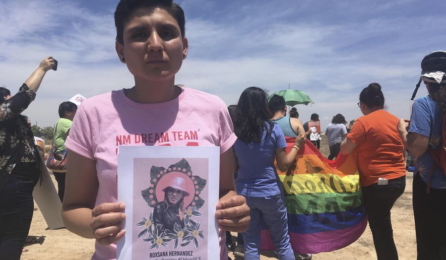 Gabriela Hernandez, executive director of the nonprofit New Mexico Dream Team, holds up an image Wednesday, June 6, 2018, in Albuquerque, N.M, of a Honduran transgender woman who died while in U.S. custody last month. Immigrant and LGBT advocates gathered outside a U.S. Immigration and Customs Enforcement office in Albuquerque to protest migrant Roxsana Hernandez's death, which authorities say came after she developed symptoms of pneumonia, dehydration and complications associated with HIV. (AP Photo/Mary Hudetz).