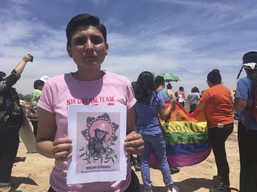 Gabriela Hernandez, executive director of the nonprofit New Mexico Dream Team, holds up an image Wednesday, June 6, 2018, in Albuquerque, N.M, of a Honduran transgender woman who died while in U.S. custody last month. Immigrant and LGBT advocates gathered outside a U.S. Immigration and Customs Enforcement office in Albuquerque to protest migrant Roxsana Hernandez's death, which authorities say came after she developed symptoms of pneumonia, dehydration and complications associated with HIV. (AP Photo/Mary Hudetz).