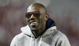 FILE - In this Nov. 19, 2016, file photo, former NFL wide receiver and Chattanooga alum Terrell Owens walks the sidelines during the second half of an NCAA college football game between Alabama and Chattanooga, in Tuscaloosa, Ala. Terrell Owens says he will not attend the induction ceremony for the Pro Football Hall of Fame in August, an unprecedented decision by an enshrinee. Owens was voted into the hall in February. In a statement released Thursday, June 7, 2018, by his publicist, Owens says: “While I am incredibly appreciative of this opportunity, I have made the decision to publicly decline my invitation to attend the induction ceremony in Canton.”(AP Photo/Brynn Anderson, File) **FILE**