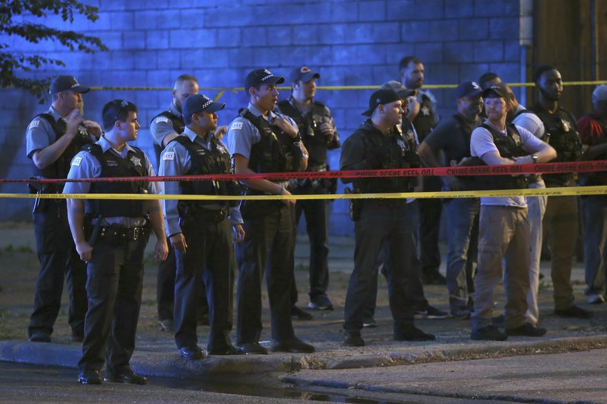 In this Wednesday, June 6, 2018 photo, Chicago Police remain at the scene of a shooting near 47th Street and Prairie Avenue in Chicago. (Terrence Antonio James/Chicago Tribune via AP)