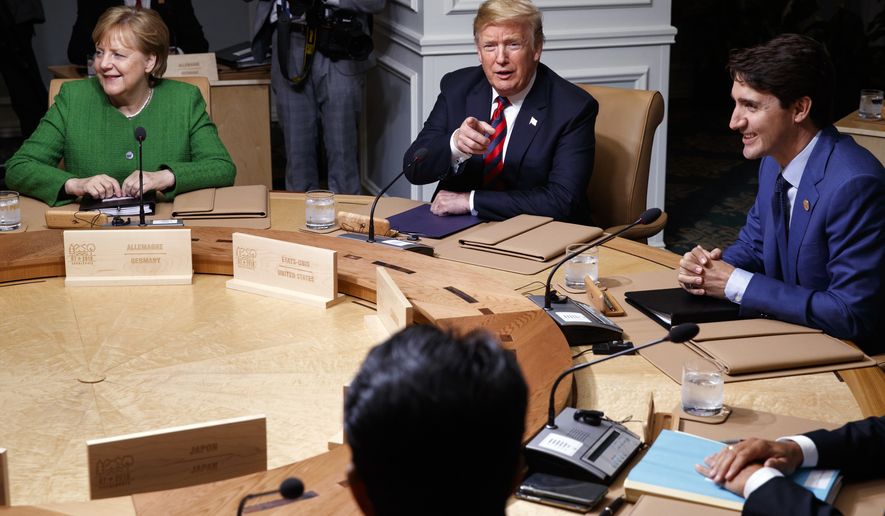 German Chancellor Angela Merkel, President Donald Trump, and Canadian Prime Minister Justin Trudeau participate in a G-7 summit working session, Friday, June 8, 2018, in Charlevoix, Canada. (AP Photo/Evan Vucci)