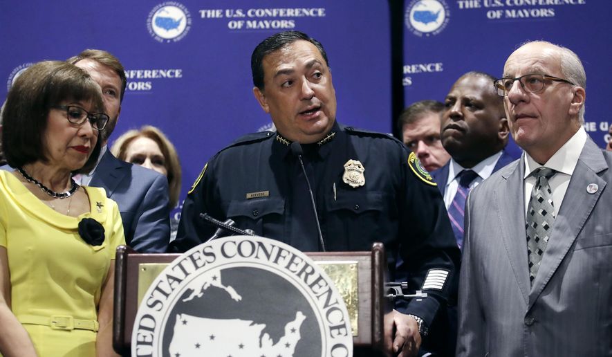 Houston Police Chief Art Acevedo, center, stands with Burnsville, Minn. Mayor Elizabeth Kautz, left, and Pembroke Pines, Fla. Mayor Frank Ortis during the annual meeting of the U.S. Conference of Mayors in Boston, Friday, June 8, 2018. More than 250 city executives gathered to discuss their concerns including infrastructure, school safety, immigration and the economic future of cities. (AP Photo/Charles Krupa)