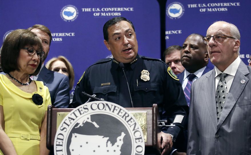 Houston Police Chief Art Acevedo, center, stands with Burnsville, Minn. Mayor Elizabeth Kautz, left, and Pembroke Pines, Fla. Mayor Frank Ortis during the annual meeting of the U.S. Conference of Mayors in Boston, Friday, June 8, 2018. More than 250 city executives gathered to discuss their concerns including infrastructure, school safety, immigration and the economic future of cities. (AP Photo/Charles Krupa)