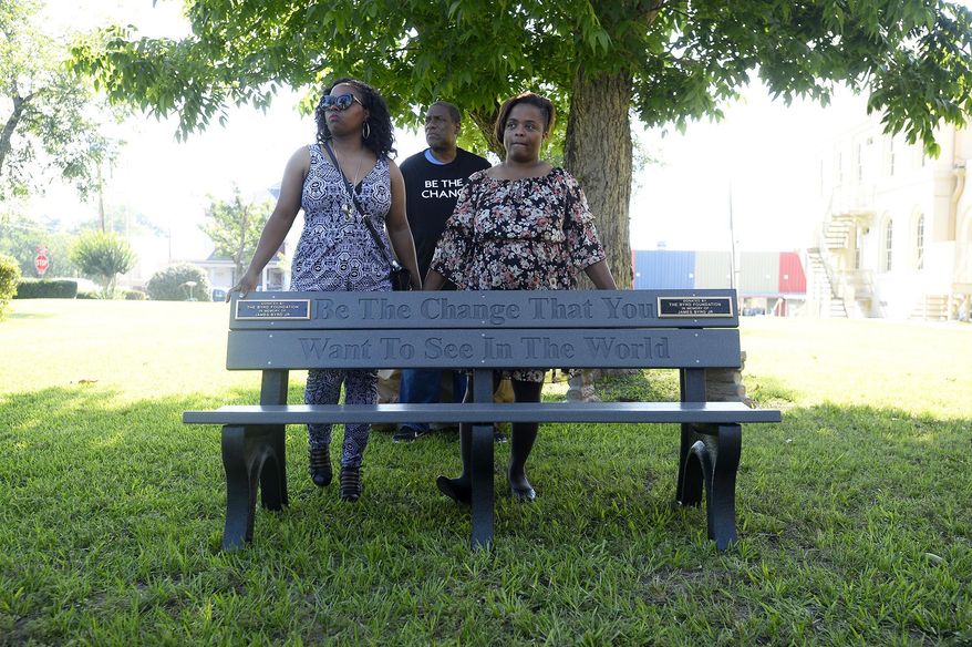 Jamie Byrd-Grant, daughter, Renee Mullins, daughter, and Thurman Byrd, brother, unveil a bench in memory of James Byrd Jr. on the lawn of the Jasper County Courthouse in Jasper, Texas, Thursday, June 8, 2018. (Ryan Pelham/The Beaumont Enterprise via AP)