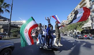 FILE - In this April 14, 2018, file photo, Syrian government supporters wave Syrian, Iranian and Russian flags as they chant slogans against U.S. President Trump during demonstrations following a wave of U.S., British and French military strikes to punish President Bashar Assad for suspected chemical attack against civilians, in Damascus, Syria. Russia&#39;s deployment near the Syria-Lebanon border this week and its withdrawal a day later after protests from the militant Hezbollah group reveals some of the uneasy relations between allies of President Bashar Assad who joined the country&#39;s civil war to back him. The move comes amid calls by Russia for foreign countries to withdraw troops from Syria while Tehran says it presence will remain as long as there are threats from terrorists. (AP Photo/Hassan Ammar, File)