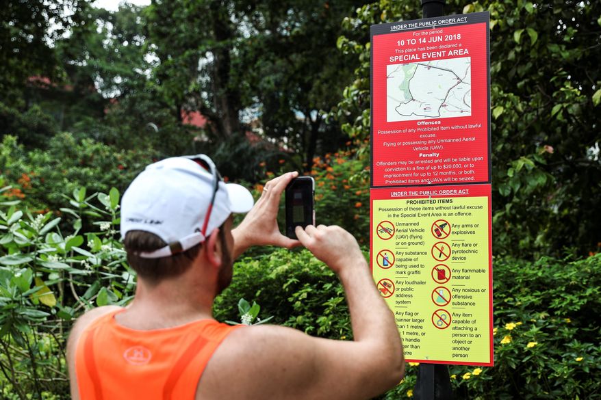 A man photographs a police notice outside the St. Regis Hotel in Singapore on Sunday. (Associated Press)