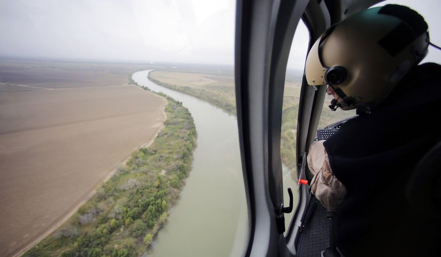 FILE - In this Tuesday, Feb. 24, 2015, aerial file photo, a U.S. Customs and Border Protection Air and Marine agent looks out along the Rio Grande on the Texas-Mexico border in Rio Grande City, Texas. U.S. Homeland Security Secretary Kirstjen Nielsen said Wednesday, April 4, 2018, that President Donald Trump and border-state governors are working to immediately deploy the National Guard to the U.S.-Mexico border to fight illegal immigration. (AP Photo/Eric Gay, File)